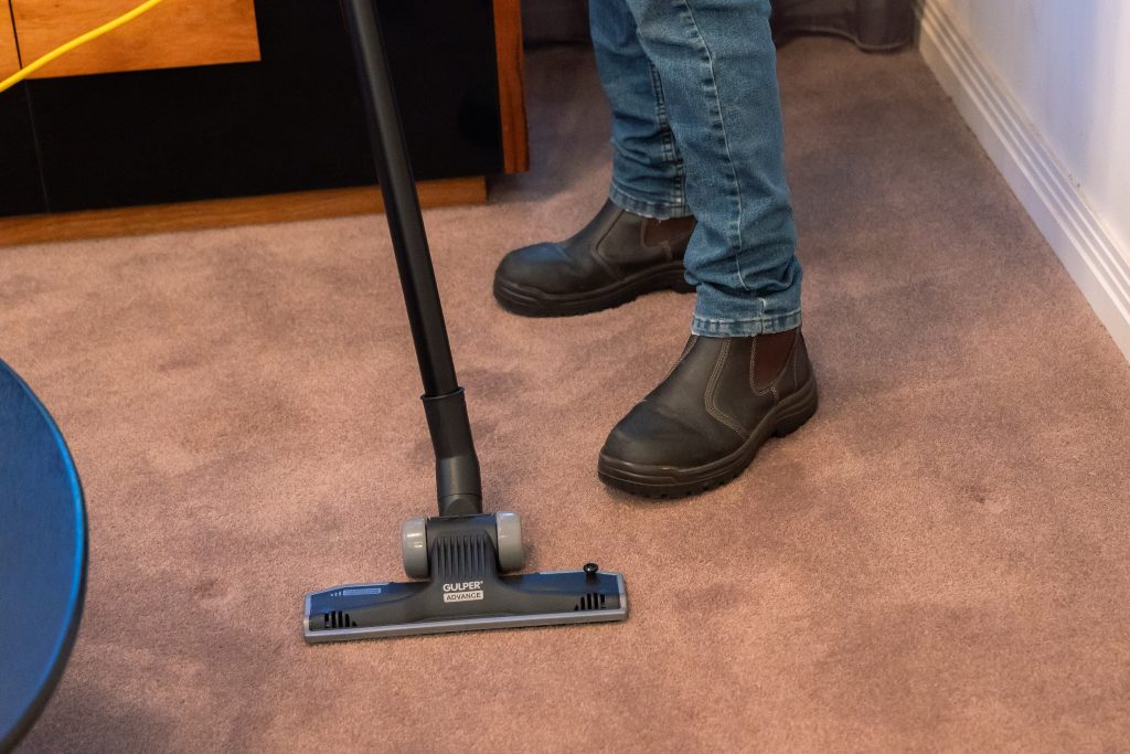 Perth cleaner vacuuming a carpet floor