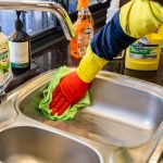 cleaner scrubbing the inside of sink