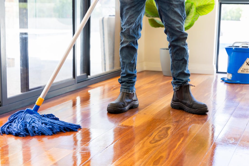 cleaner mopping a polished wooden floor